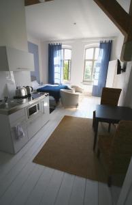 a room with a kitchen and a living room with a bed at Nr9Marinehafen - Ferienwohnungen in Stralsund