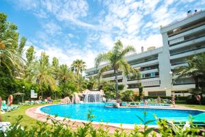 a swimming pool with a fountain in front of a building at Ona Jardines Paraisol in Salou