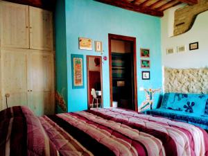 a bedroom with a large bed and blue walls at la cana dolce in Bertinoro