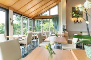 restauracja ze stołami, krzesłami i oknami w obiekcie Hotel Haus Arenberg w mieście Salzburg