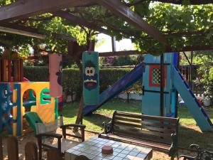 a playground with a bench and a slide at Oasis in Skiathos