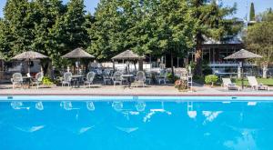 a swimming pool with chairs and tables and umbrellas at Silver Bay Hotel Kontokali Corfu in Kontokali +25 photos