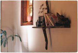 a book shelf on a wall with books on it at Sum Villa Homestay Mang Den in Kon Von Kla