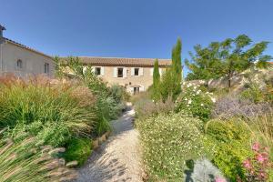 un jardin fleuri et un bâtiment en arrière-plan dans l'établissement Domaine de Puychêne, à Saint-Nazaire-dʼAude