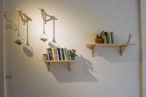 een muur met twee boekenplanken en enkele boeken bij KM Hostel in Chiayi City