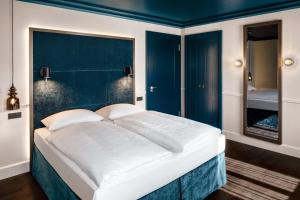 
a hotel room with a white bed and white walls at Hotel AMO by AMANO Friedrichstraße in Berlin

