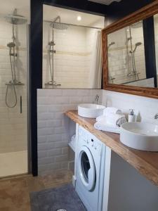 y baño con 2 lavabos y lavadora. en Le Clos des Bories Le Gîte, en Sarlat-la-Canéda