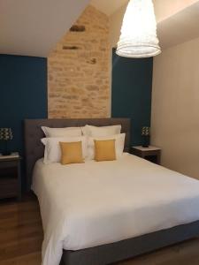 1 dormitorio con 1 cama blanca grande y 2 almohadas en Le Clos des Bories Le Gîte, en Sarlat-la-Canéda