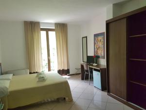a hotel room with a bed and a television at Hotel & Residence La Sibilla Cusiana in Pettenasco