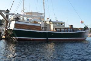 a green and white boat sitting in the water at Wharfside Bed & Breakfast in Friday Harbor