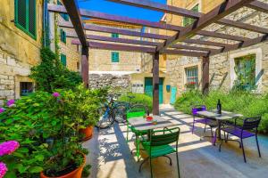 a patio with tables and chairs and some plants at Apartments Veig in Split