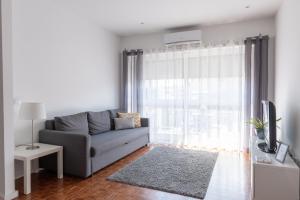 a living room with a couch and a window at Casa Marquês in Porto