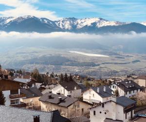 a village with snow covered mountains in the background at Résidence Le Pic de l'Ours in Font-Romeu