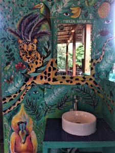 Casa Kiwi Hostel في ميديلين: حمام مع حوض مع لوحة على الحائط
