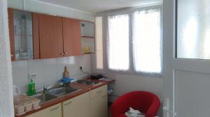 eine kleine Küche mit Spüle und rotem Stuhl in der Unterkunft Apartments Lončarević in Slano + 28 Fotos