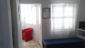 Zimmer mit einem roten Stuhl und einem Fenster in der Unterkunft Apartments Lončarević in Slano