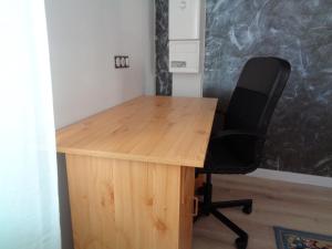 - un bureau en bois avec une chaise noire dans l'établissement Appartement indépendant LE PANASSA, Centre ville, Garage privé, à Saint-Étienne