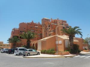 un gran edificio con coches estacionados en un estacionamiento en Estudio Fenix LOS MOLINILLOS, en Roquetas de Mar