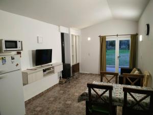 ein Wohnzimmer mit einem Kühlschrank und einem TV in der Unterkunft Casa en Santa Rosa de Calamuchita in Santa Rosa de Calamuchita