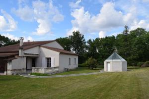 a small white house with a grassy yard at LE CHEMINARD in Feugarolles