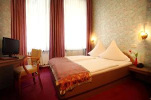 a hotel room with a bed and a television at Astoria Hotel in Trier