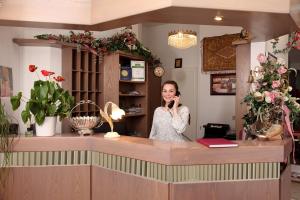 Eine Frau, die auf einem Handy an einer Theke spricht in der Unterkunft Astoria Hotel in Trier