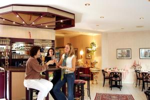 twee vrouwen aan een bar in een restaurant bij Astoria Hotel in Trier