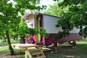 una casita roja y blanca sentada en un campo en La roulotte Chic et Boheme, en Mazan