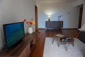 uma sala de estar com uma grande televisão de ecrã plano em Freda House no Funchal