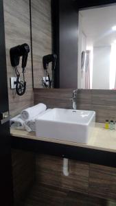 a bathroom with a white sink and a mirror at Hotel WLH Bogota - White Lighthouse in Bogotá