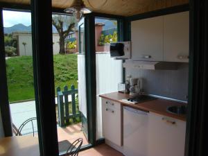 a kitchen with an open door to a patio at Apartamentos del Norte in Andrín