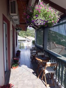 a balcony with tables and chairs and flowers at Ana & Stela in Karlobag