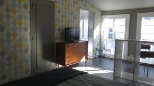 een slaapkamer met een bed en een televisie op een dressoir bij Studio Flow Libourne in Libourne