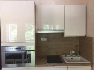a kitchen with white cabinets and a sink at ARENA PULA CENTAR APARTMENT in Pula