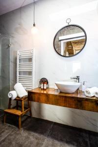 a bathroom with a sink and a mirror at Pjazza Suites Boutique Hotel by CX Collection in Siġġiewi