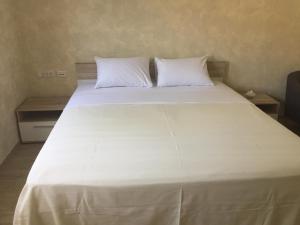 a large white bed with two pillows on it at ARENA PULA CENTAR APARTMENT in Pula
