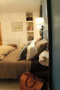 a bedroom with a bed with pillows and a suitcase at La Demeure des Maitres in Chirols