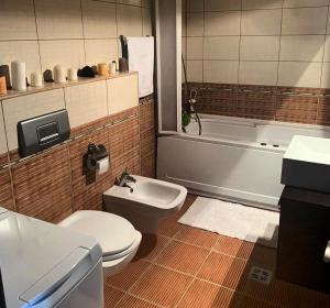 a bathroom with a toilet and a tub and a sink at Apartament Vila Maria in Mamaia +7 photos