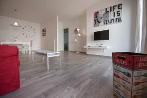 a white living room with a table and a tv at Apartment Bolsena Casa Vacanze in Bolsena