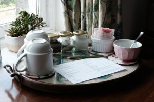 a glass table with jars and a paper on it at Denson Villa in Nairn