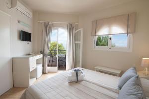 a bedroom with a large bed and a balcony at Nautilus Nontas Hotel in Megalochori