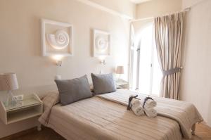 a bedroom with a bed with two pairs of shoes on it at Nautilus Nontas Hotel in Megalochori