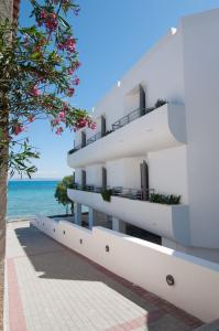 a white building with the ocean in the background at Nautilus Nontas Hotel in Megalochori