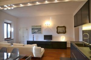 a living room with a white couch and a tv at S.M. VICOLO DELL'ORO in San Gimignano