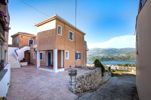 dom z kamienną ścianą obok jeziora w obiekcie Antigone Apartments Argostoli (Spilia) 2 w mieście Argostoli