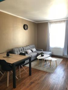uma sala de estar com um sofá e uma mesa em appartement de charme en plein coeur du centre ville de Compiègne arriver entre 14h et 18h maximum em Compiègne