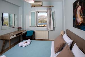 sypialnia z łóżkiem, biurkiem i oknem w obiekcie Antigone Apartments Argostoli (Spilia) 2 w mieście Argostoli