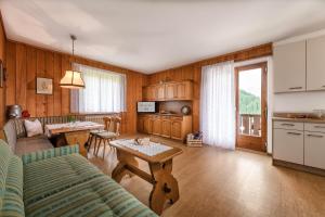 cocina y sala de estar con sofá y mesa en Ringlerhof en Braies (Prags)