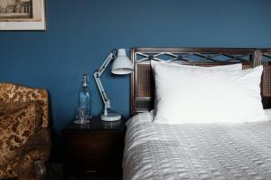 a blue bedroom with a bed and a lamp on a table at Denson Villa in Nairn
