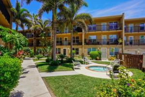 un edificio de apartamentos con piscina y palmeras en South Padre Island Gulf Getaway With Pool Condo, en South Padre Island